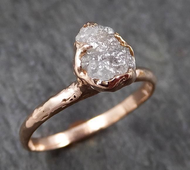 a gold ring with a rough diamond in the center