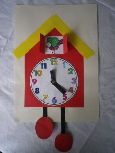 a clock made out of construction paper on top of a sheet of paper