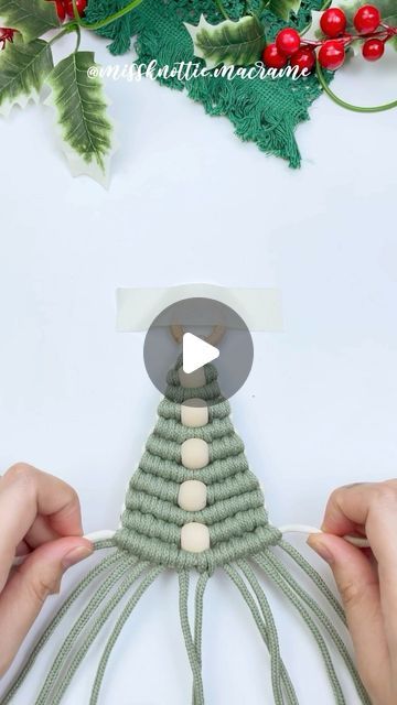 someone is making a christmas tree decoration out of yarn