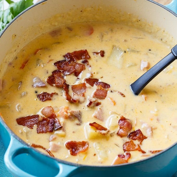 a blue pot filled with bacon and cheese soup on top of a blue table cloth