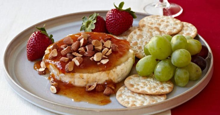 a white plate topped with fruit and crackers