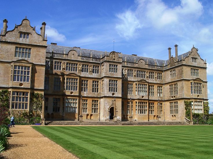 a large building with lots of windows and green grass in front of it on a sunny day