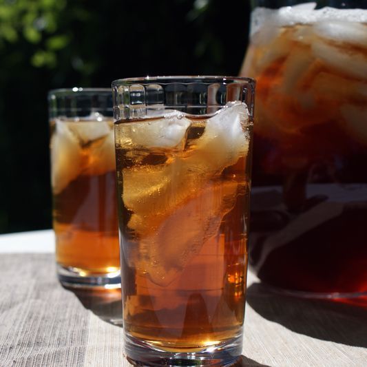 two glasses filled with liquid sitting on top of a table next to an ice bucket