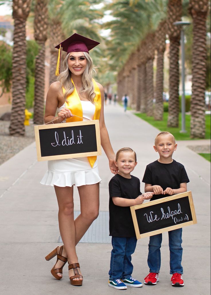 a woman and two children holding signs that read i did it with chalkboard writing on them