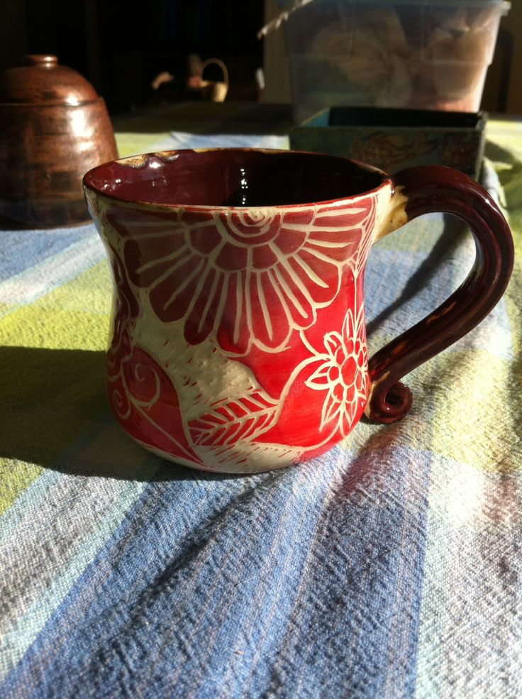 a red and white mug sitting on top of a table