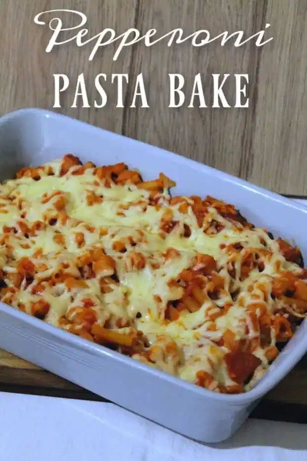 a casserole dish with meat and cheese in it on a wooden table next to a white napkin