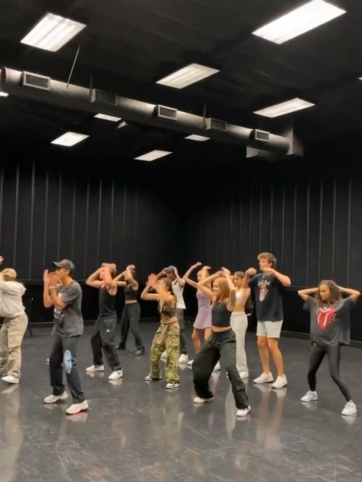 a group of people standing on top of a dance floor in front of a black wall