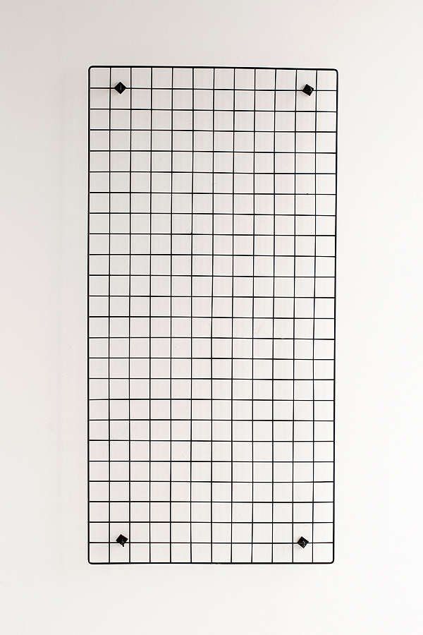 a white wall with a grid pattern on the bottom and two black dots in the middle