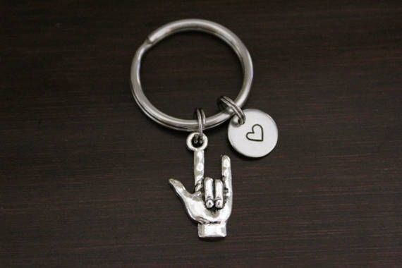 a metal keychain with a hand and heart on it