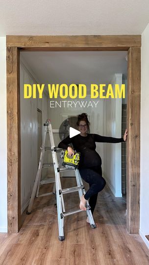 a woman standing on a ladder in front of a wall with the words diy wood beam entryway