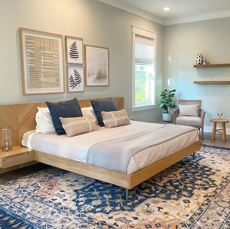 a large bed sitting in the middle of a bedroom next to a window and rug