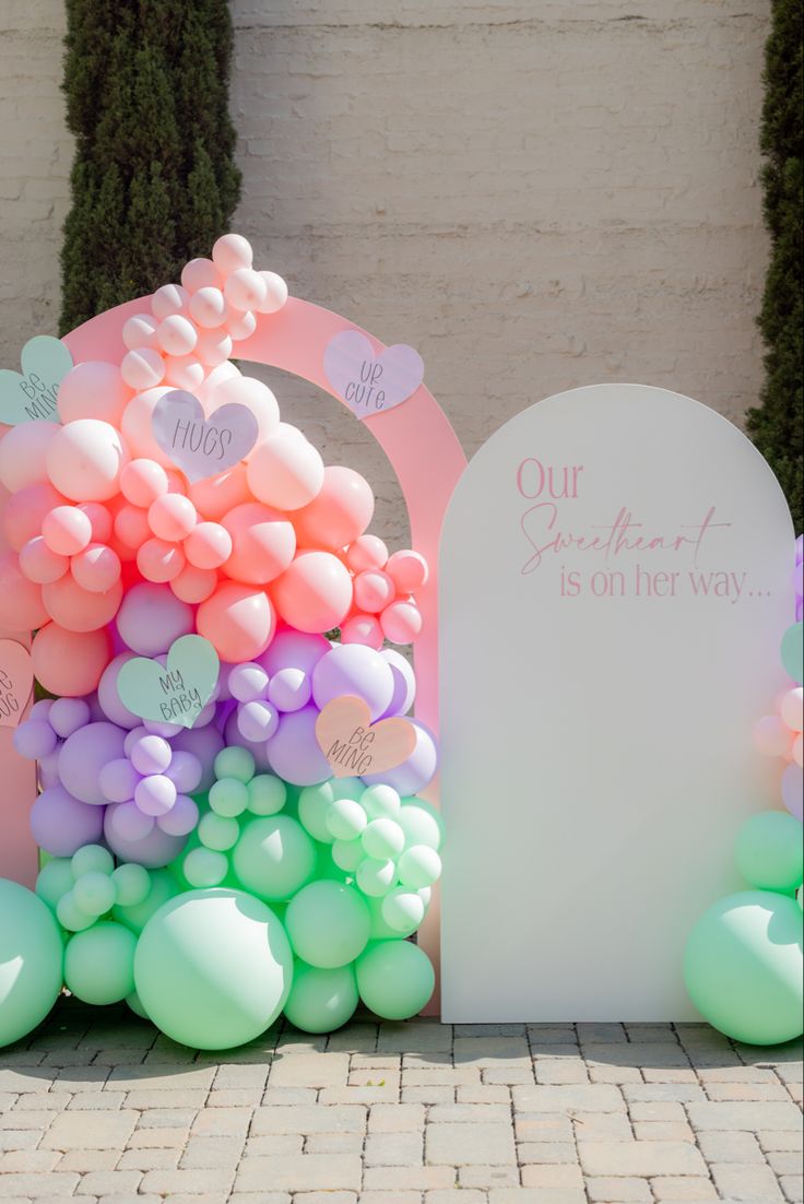 an arch decorated with balloons in the shape of hearts