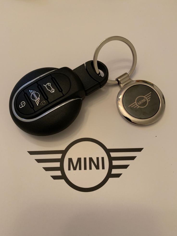 a car keychain with the word mini on it next to a pair of keys