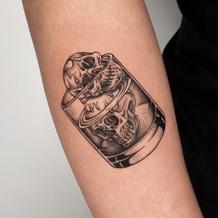 a black and white photo of a skull in a jar tattoo on the right arm