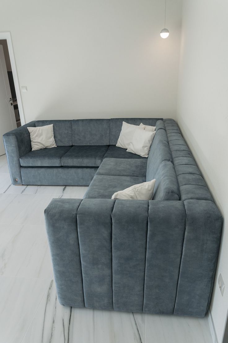 a large blue couch sitting on top of a white floor