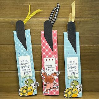 three bookmarks with different designs on them sitting next to each other in front of a wooden wall