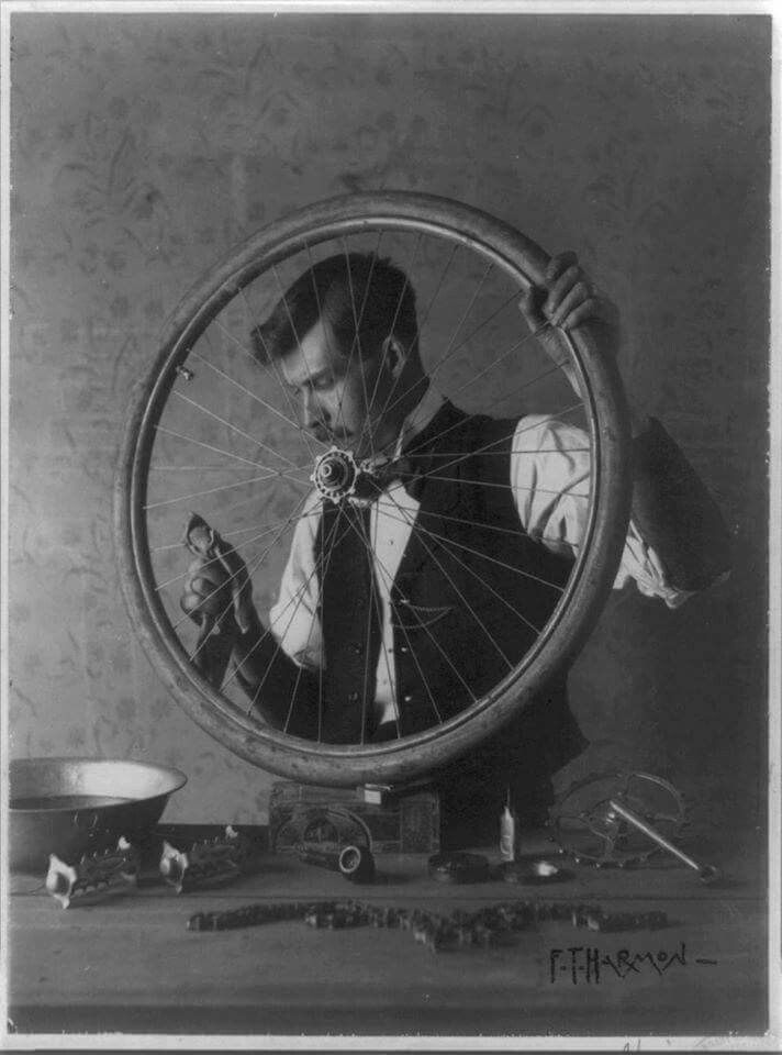 a man holding a bicycle wheel in front of his face