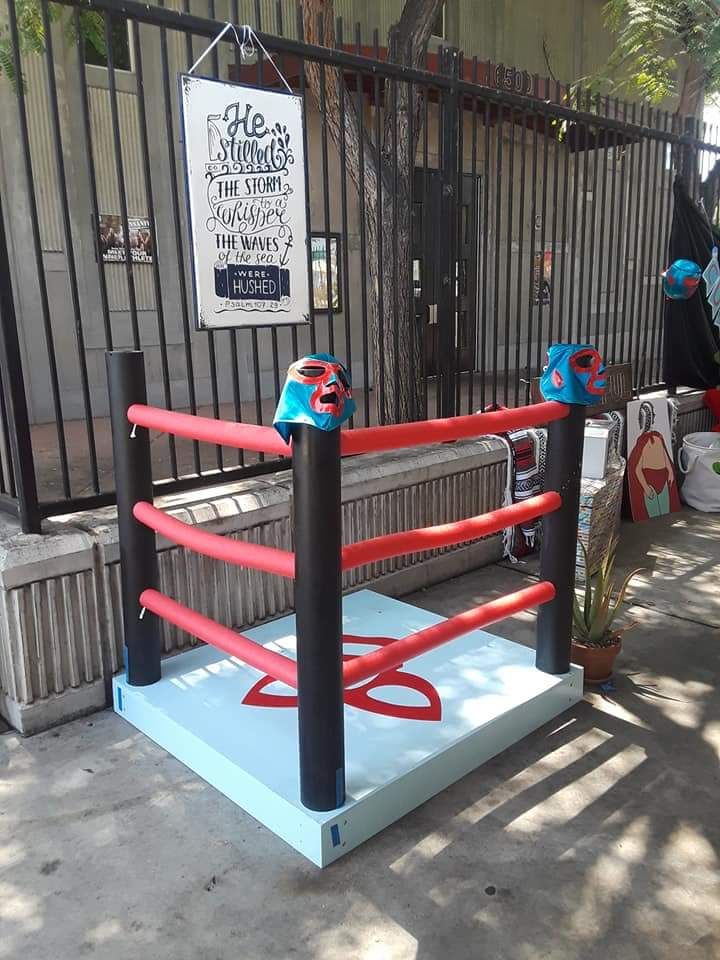 a blue and red boxing ring sitting in front of a gated entrance to a building