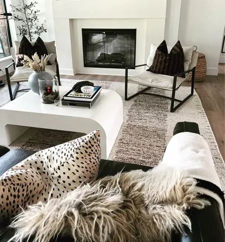 a living room filled with furniture and a fire place in the middle of the room