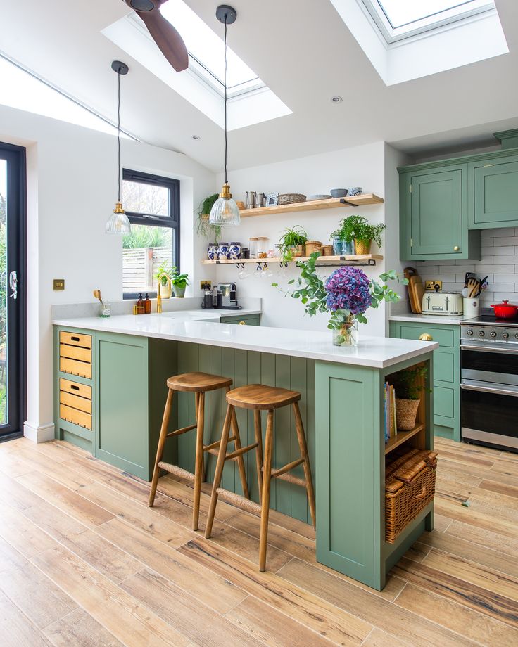 a kitchen with two stools in front of an island and skylights above it