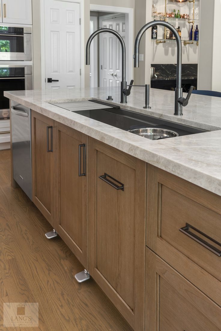 a kitchen with wooden cabinets and stainless steel sink faucets in front of an oven