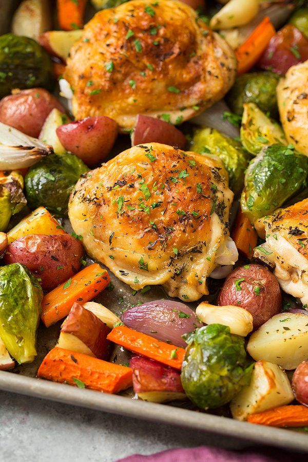 a pan filled with chicken, potatoes and veggies