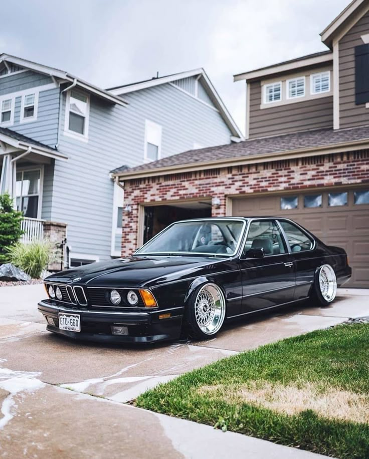 a black car parked in front of a house