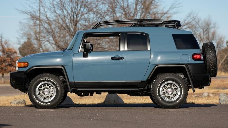 a blue toyota fj cruiser parked on the side of the road