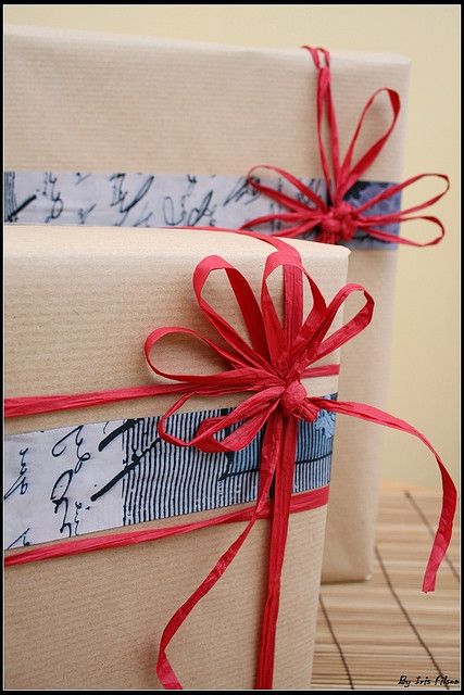 two wrapped gift boxes with red ribbons on them