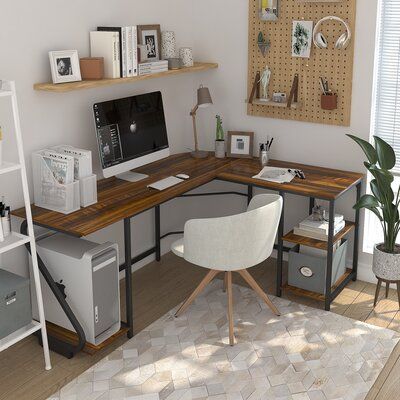 a computer desk sitting in the corner of a room next to a chair and bookshelf