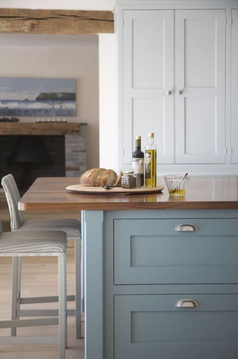 a kitchen island with two chairs and bottles on the counter next to an open fire place