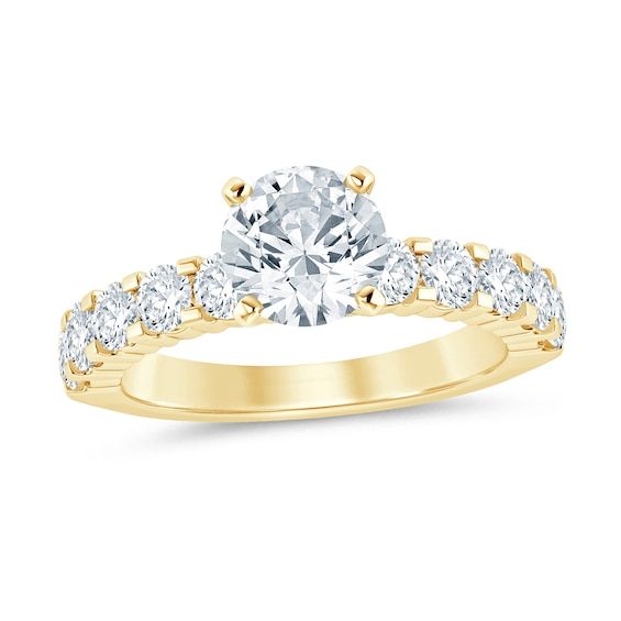 a yellow gold engagement ring with three stones on the band and an oval cut diamond