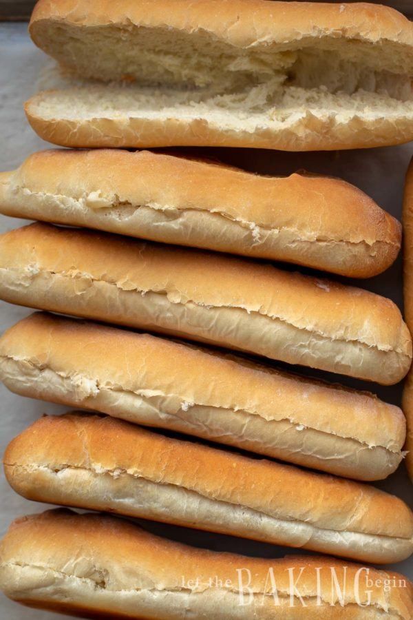 a bunch of hot dogs that are sitting on a table together in a pile with the buns sticking out