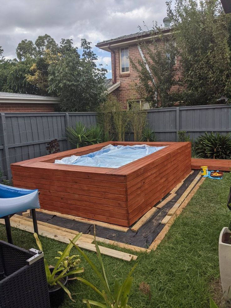 a wooden hot tub sitting in the middle of a yard