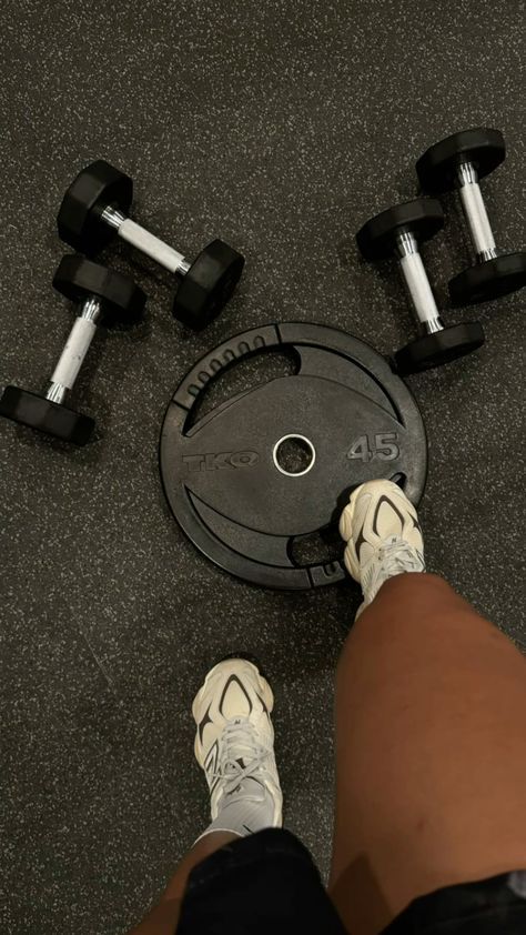 a person standing next to two dumbbells on the ground