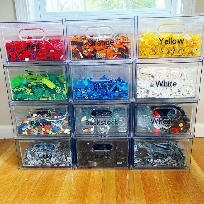 plastic storage bins filled with different types of toy cars and toys in front of a window