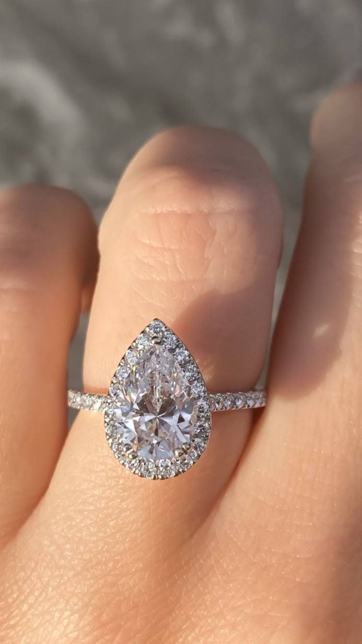 a woman's hand with a diamond ring on it and an engagement band in the middle