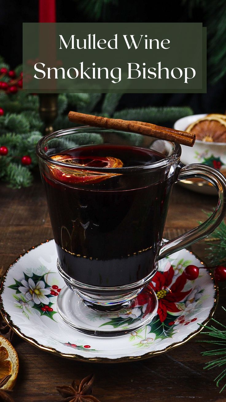 a cup of mulled wine sitting on top of a saucer with a cinnamon stick in it