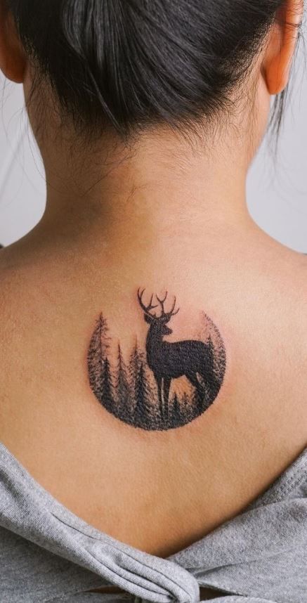 a woman with a deer tattoo on her back neck and behind her is a forest scene