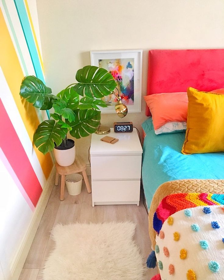 a bedroom with a bed, nightstand and colorful walls