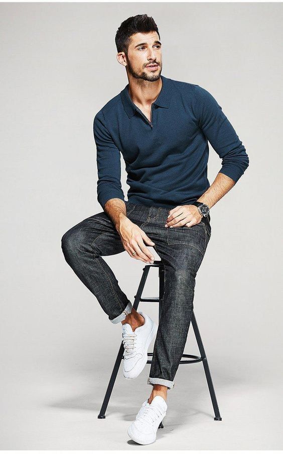 a man sitting on top of a stool wearing a blue shirt and black jean pants