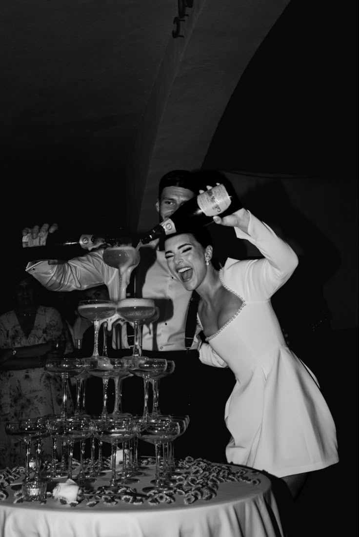 a man and woman standing next to each other in front of a cake on a table