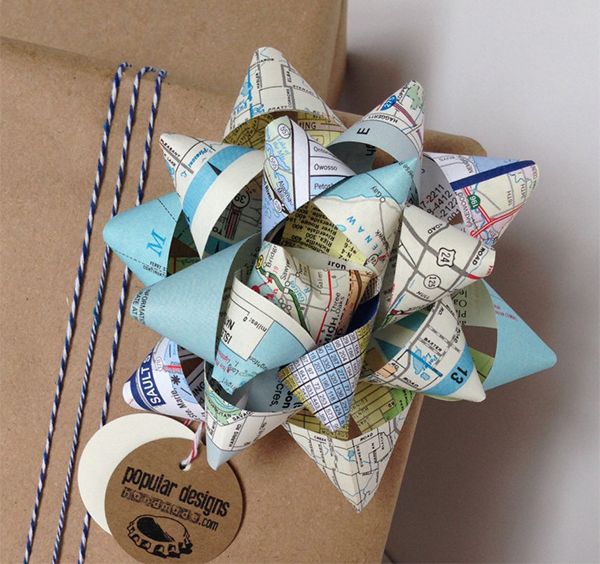 an origami flower on top of a brown box with blue and white paper