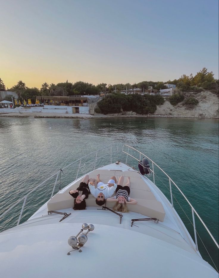 two people laying on the back of a boat