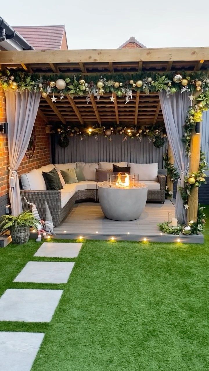 an outdoor living area is decorated with greenery and lights