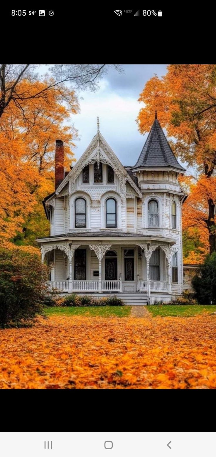 an old victorian house surrounded by fall leaves