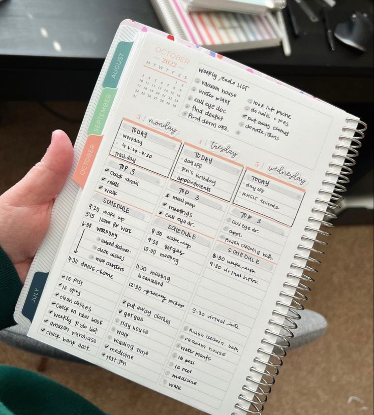 a person holding a planner in their hand with writing on the pages and other things to do