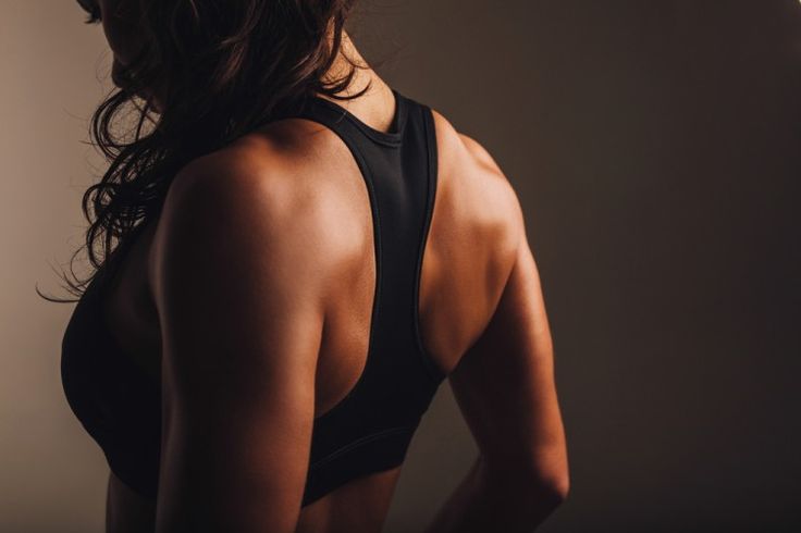 a woman in a black sports bra with her back to the camera