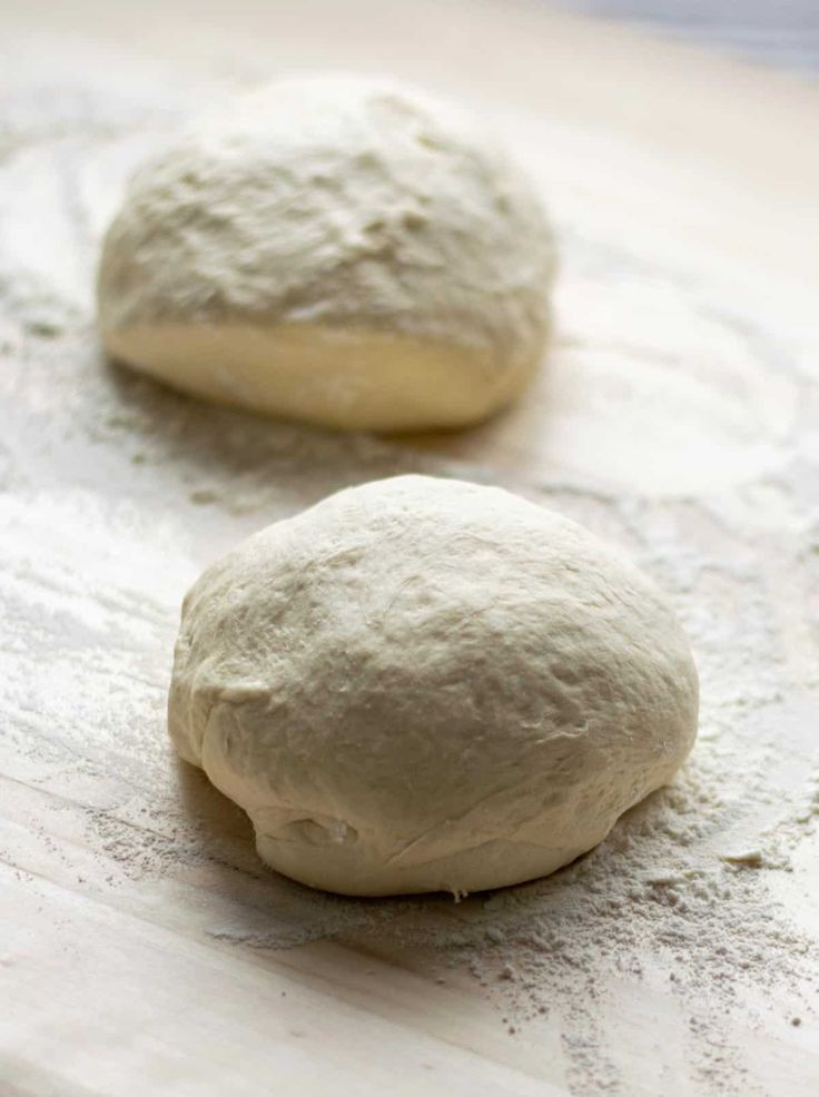 two uncooked doughnuts sitting on top of a table