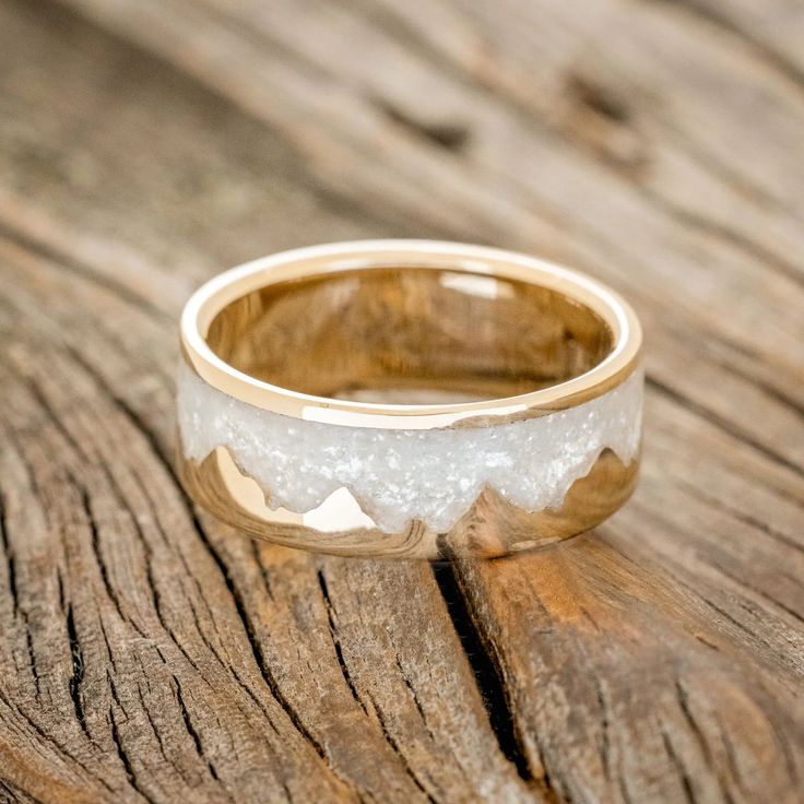 a close up of a wedding ring on a wooden surface